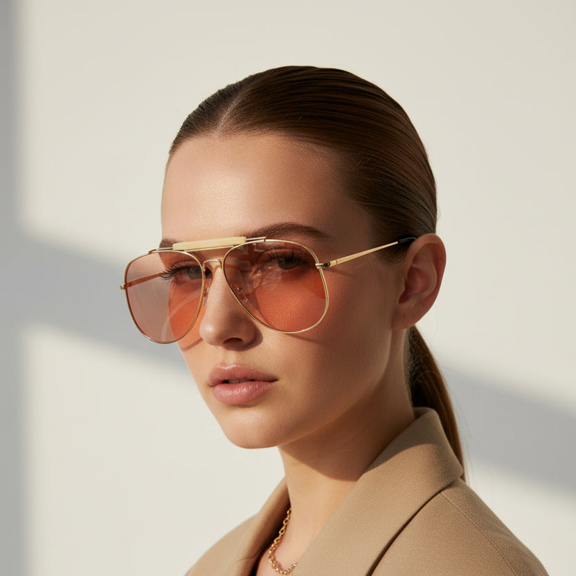 Aviator sunglasses with gold frame and rose gold lenses on a white background